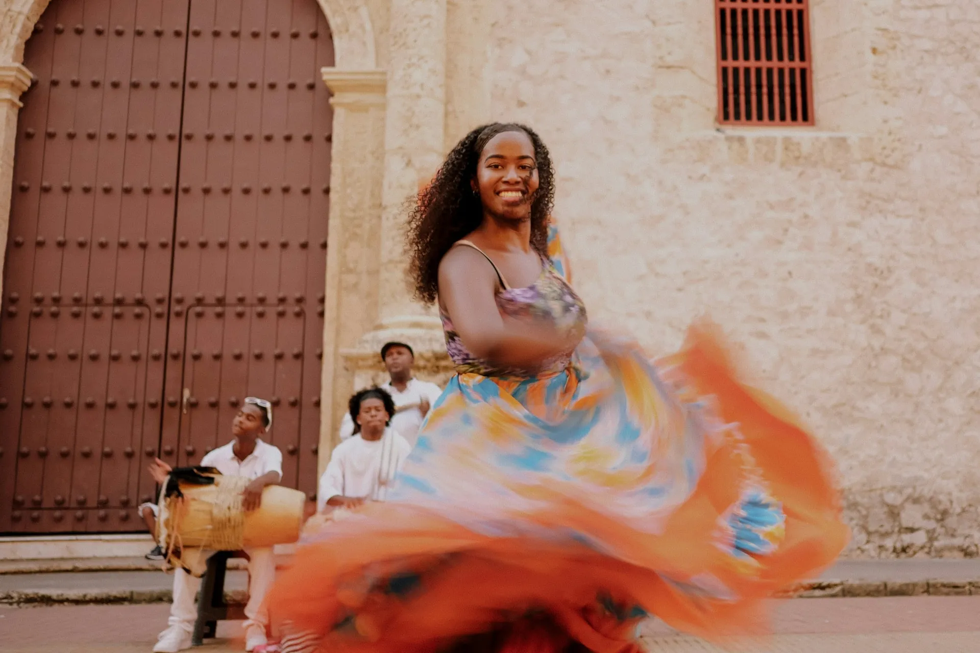 A Colombian folk dancer in a bright traditional costume mid-performance